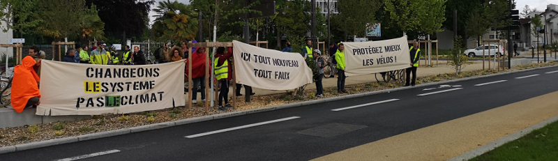 image des banderoles &ldquo;ici tout nouveau tout faux&rdquo;, &ldquo;protégez mieux les vélos&rdquo;, et &ldquo;changeons le système pas le climat&rdquo;